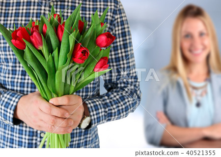 Picture of young man surprising woman with flowers 40521355