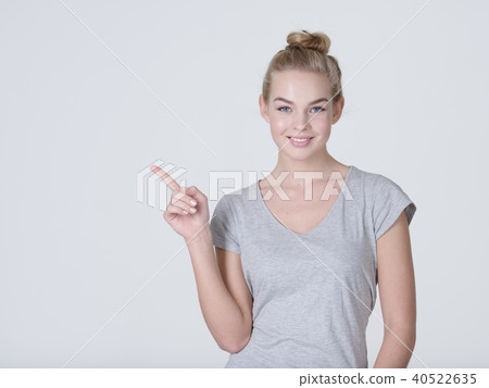 Smiling pretty woman pointing finger away Smiling pretty woman pointing finger away 40522635