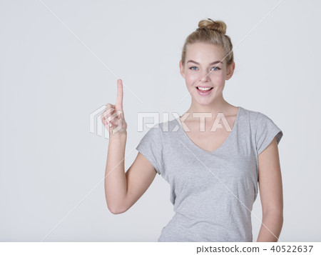Smiling pretty woman pointing finger up Smiling pretty woman pointing finger up 40522637