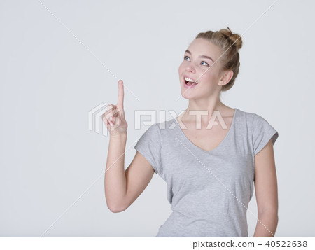 Smiling pretty woman pointing finger up 40522638
