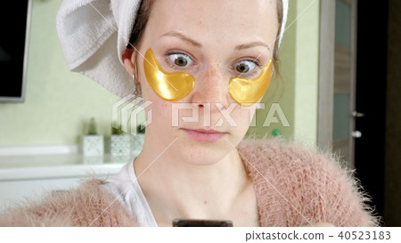 attractive woman spplying cosmetic facial patches at home attractive woman spplying cosmetic facial patches at home 40523183