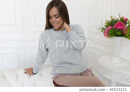 Beautiful woman in grey sweatshirt sitting on the couch. Mock-up. 40523231