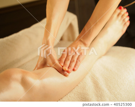 A woman who drains the knee lymph in a dim beauty salon 40525300