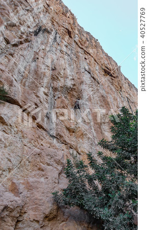 Male climber hanging by a cliff Male climber hanging by a cliff 40527769