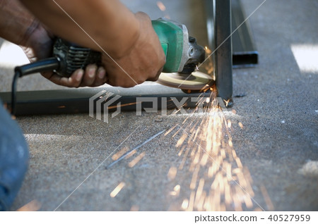 The worker is welding metal part of table steel. The worker is welding metal part of table steel. 40527959