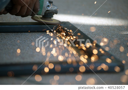 The worker is welding metal part of table steel. 40528057