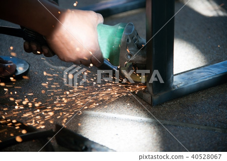 The worker is welding metal part of table steel. The worker is welding metal part of table steel. 40528067