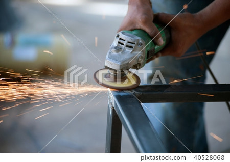 The worker is welding metal part of table steel. The worker is welding metal part of table steel. 40528068