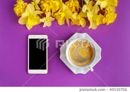 Coffee cup with narcissus flowers and smart phone 40530708