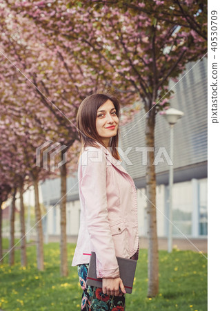 Woman portrait over pink blooming trees outside Woman portrait over pink blooming trees outside 40530709