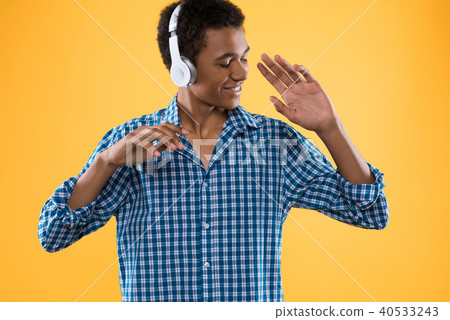Happy Afro American teenager in headphones dancing 40533243