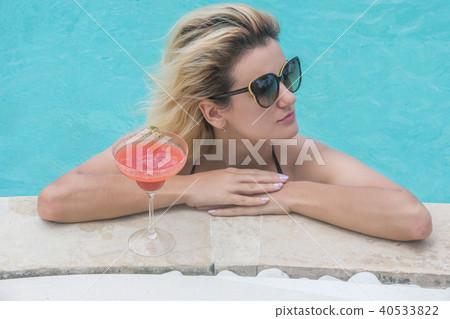 Woman in bikini with cocktail near pool Woman in bikini with cocktail near pool 40533822