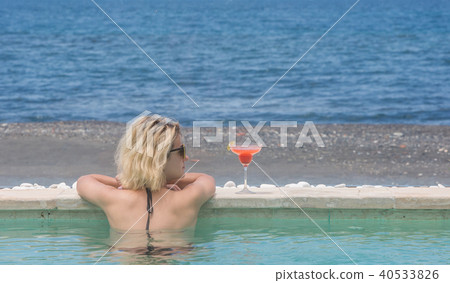 Woman in bikini with cocktail near pool Woman in bikini with cocktail near pool 40533826
