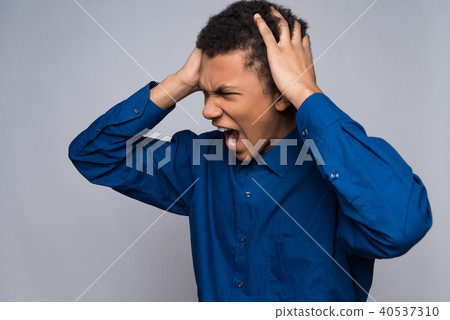 Enraged African American teenager grabs for head. Enraged African American teenager grabs for head. 40537310