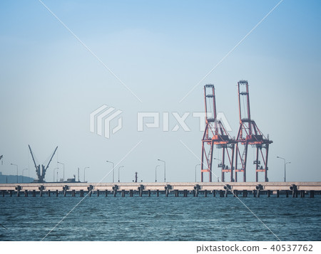 Port crane loads a container on Pier for transport 40537762