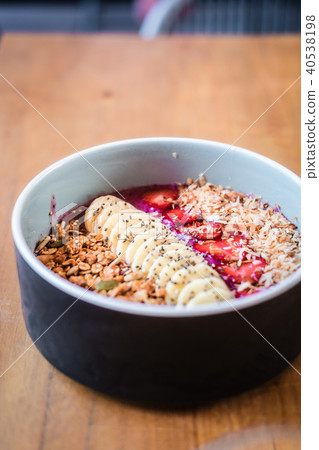 Berry smoothie bowl on wooden table 40538198