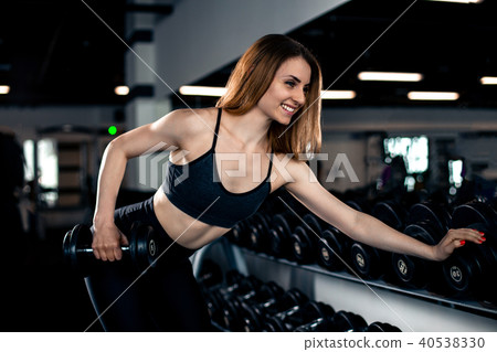 Girl doing triceps exercise with dumbbells Girl doing triceps exercise with dumbbells 40538330