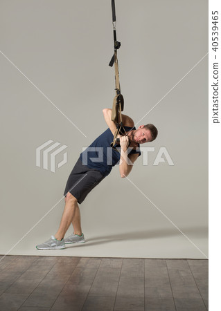 Young handsome man doing exercises in gym Young handsome man doing exercises in gym 40539465