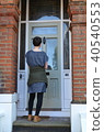 Female canvasser knocking on a green door 40540553