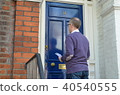 Male canvasser knocking on a blue door 40540555
