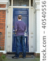 Male canvasser knocking on a blue door 40540556