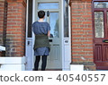 Female canvasser knocking on a green door 40540557