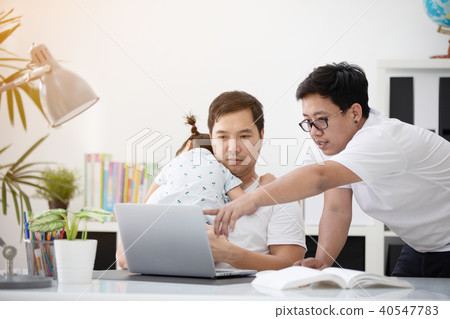 Asian family and little girl ,while dad works with notebook on w 40547783