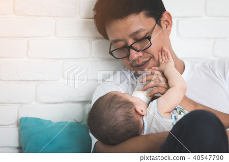 Nice moment. Agreeable young asian father holding his baby and s 40547790