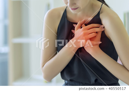 Woman pressing on chest with painful expression Woman pressing on chest with painful expression 40550517