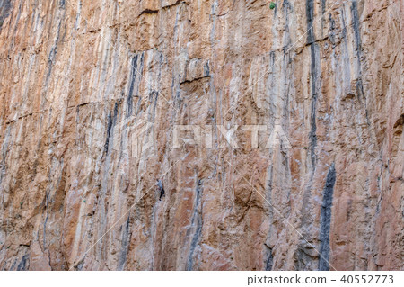 Male climber hanging in the middle of a cliff Male climber hanging in the middle of a cliff 40552773