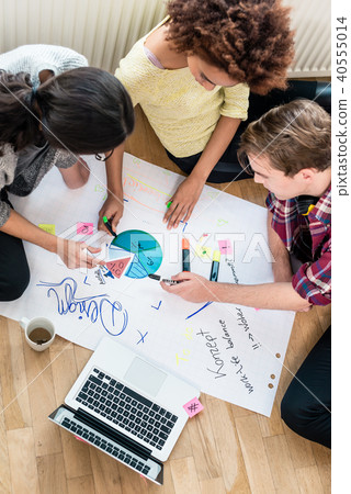 Three people writing observations during brainstorming session Three people writing observations during brainstorming session 40555014