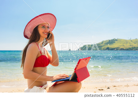 Fashionable young woman talking on mobile phone at the beach 40555112
