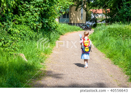 Little girl on her way to her first day of school Little girl on her way to her first day of school 40556643