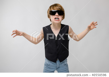 Portrait of adorable funny little boy standing in studio with sunglasses showing agression anger Portrait of adorable funny little boy standing in studio with sunglasses showing agression anger 40558596
