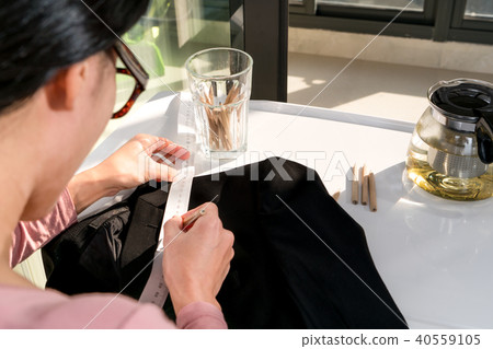 tailor woman measure the pattern on black cloth tailor woman measure the pattern on black cloth 40559105
