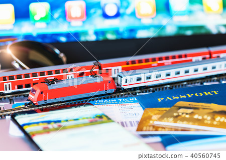 Toy train, tickets, passport and bank card on laptop or notebook 40560745