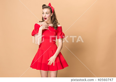 Beautiful young woman with pinup make-up and hairstyle. Studio shot on pastel background Beautiful young woman with pinup make-up and hairstyle. Studio shot on pastel background 40560747