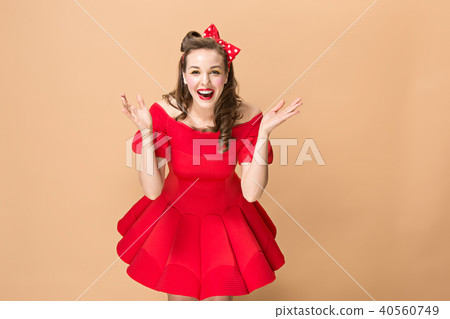 Beautiful young woman with pinup make-up and hairstyle. Studio shot on pastel background Beautiful young woman with pinup make-up and hairstyle. Studio shot on pastel background 40560749