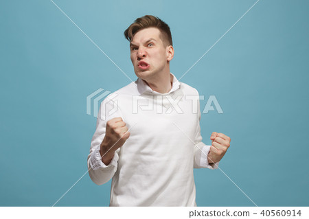 The young emotional angry man screaming on studio background 40560914