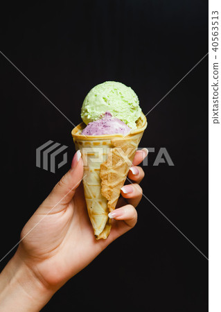 a horn with two ice cream balls in a woman's hand a horn with two ice cream balls in a woman's hand 40563513
