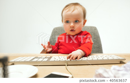 Happy child baby girl toddler sitting with keyboard of computer isolated on a white background 40563637