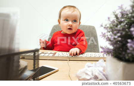 Happy child baby girl toddler sitting with keyboard of computer isolated on a white background 40563673
