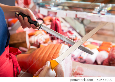 Butcher woman sharpening her knifes Butcher woman sharpening her knifes 40564000