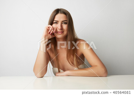 Young beautiful woman posing at the camera impressively on a light Background. Girl portrait. Beauty Young beautiful woman posing at the camera impressively on a light Background. Girl portrait. Beauty 40564081