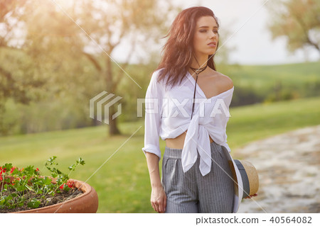 Smiling summer woman with sunglasses in italian garden Smiling summer woman with sunglasses in italian garden 40564082