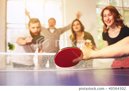 Group of happy young friends playing ping pong table tennis 40564302