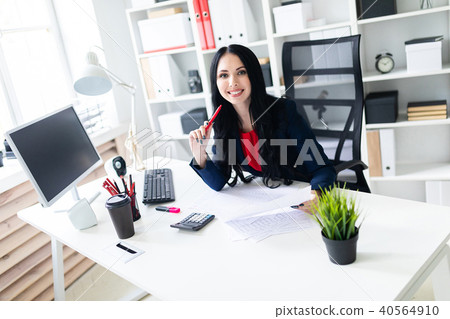 Beautiful young girl working with calculator and documents in the office at the table Beautiful young girl working with calculator and documents in the office at the table 40564910