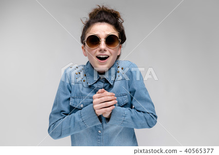 Young brunette girl in black glasses. Cat glasses. The hair is gathered in a bun. The girl folded 40565377