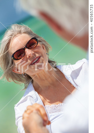 Happy Senior Couple Holding Hands on a Beach Happy Senior Couple Holding Hands on a Beach 40565735