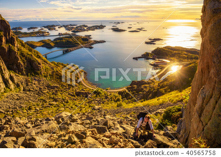 Hiker going to the top of mount Festvagtinden on Lofoten islands 40565758